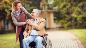 grown up daughter with father in wheelchair embracing eachother