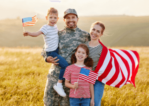 family with veteran and flags posing together