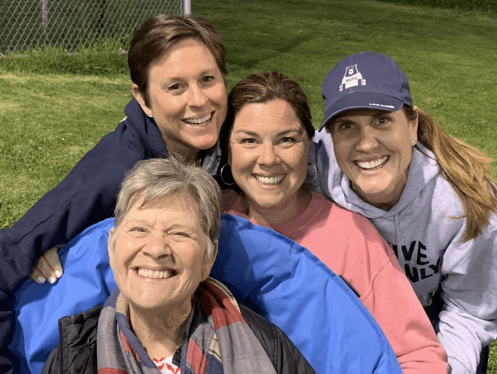 A group of mother smiling on a sports field together