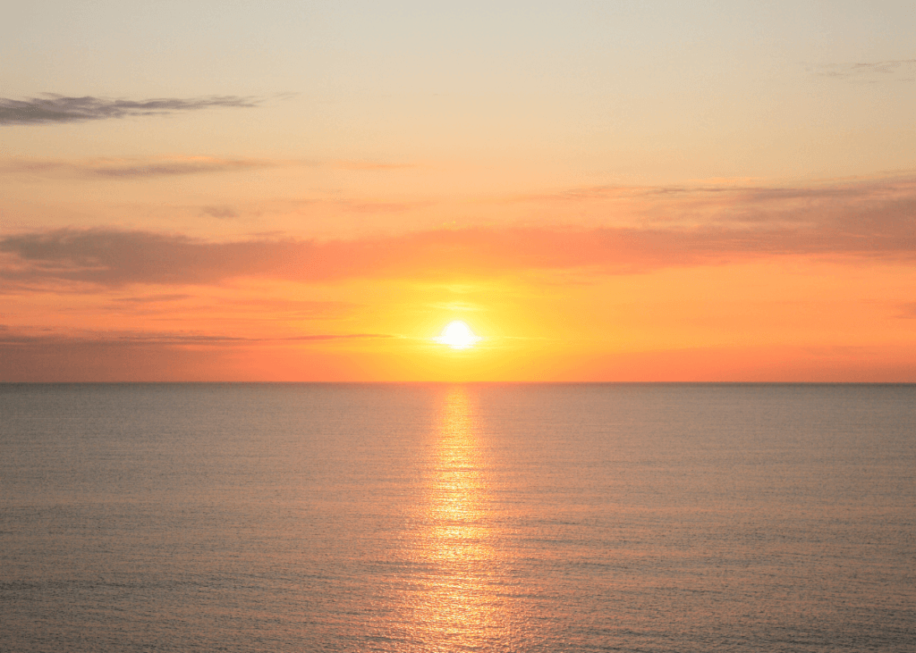 sun sets over the ocean