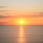 sun sets over the ocean