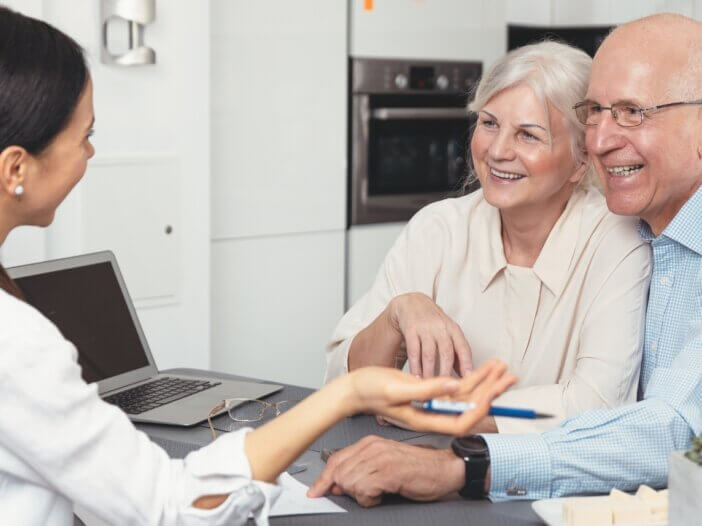 older couple with their lawyer at the kitchen table planning their estate