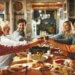 family around the thanksgiving table putting their glasses together cheersing