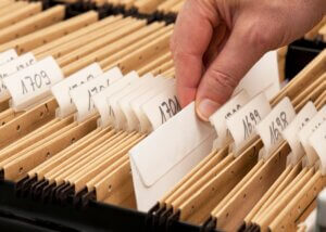 an image of documents in a file being sorted by year.