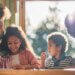 An image of a family of four with a mother, father, and two kids talking and spending time together.