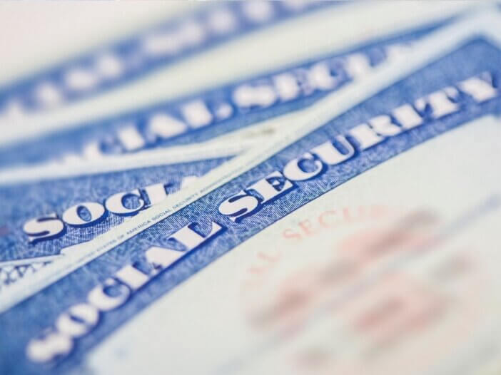 Multiple Social Security cards stacked on top of each other.