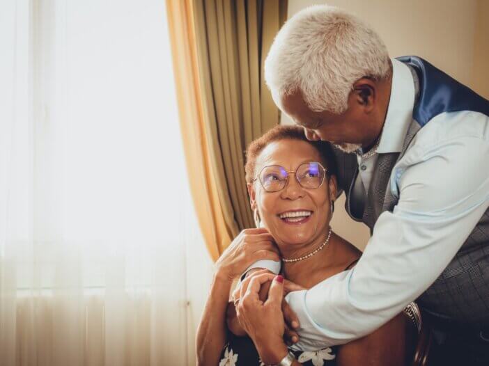 a picture of a couple in love, looking at each other. the man is hugging the wife and the wife is looking at him with love. they have created an estate plan so their future is secure.