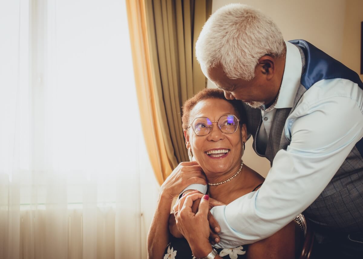 a picture of a couple in love, looking at each other. the man is hugging the wife and the wife is looking at him with love. they have created an estate plan so their future is secure.