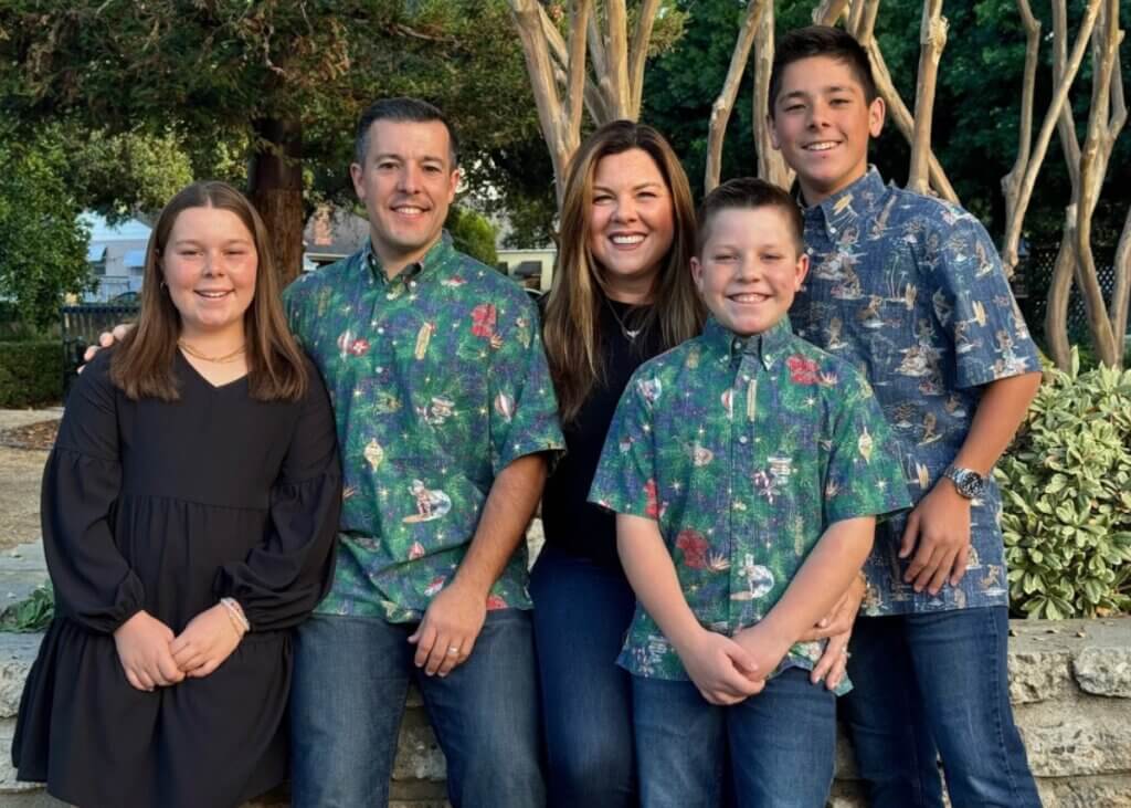 a picture of a family- the two parents and their two sons and daughter. all close together and smiling.