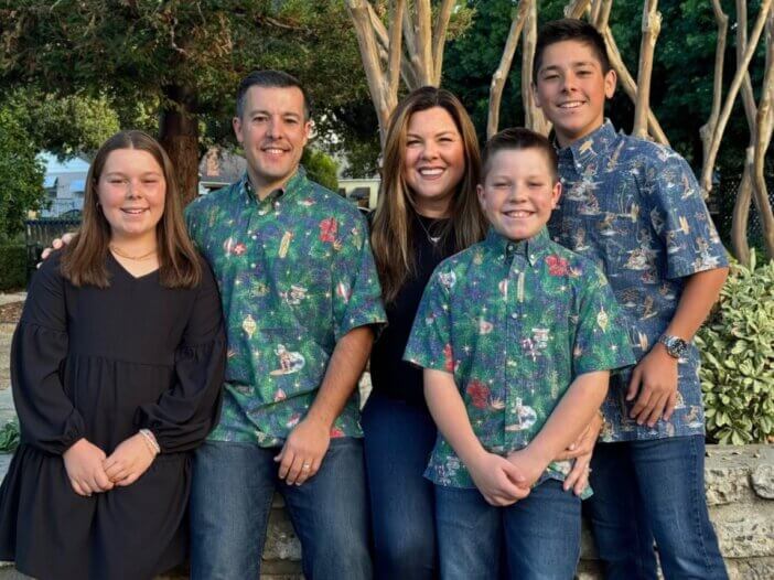 a picture of a family- the two parents and their two sons and daughter. all close together and smiling.